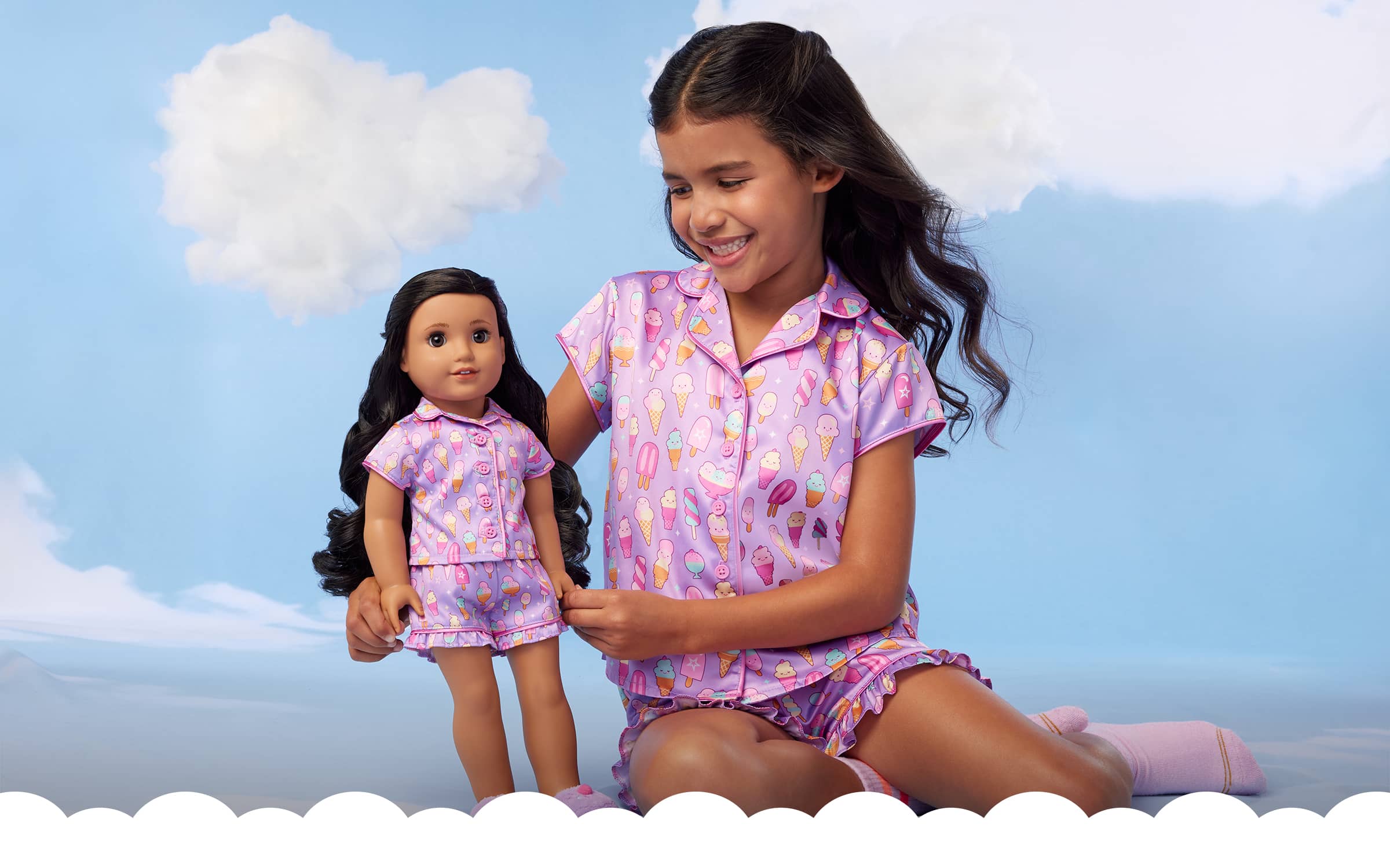 Image of young girl and her American Girl doll in matching pajamas